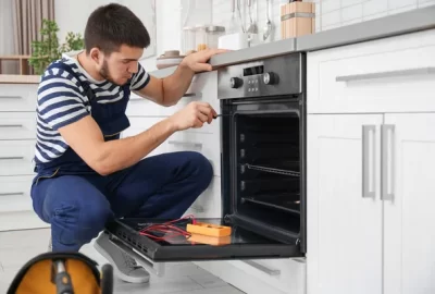 depositphotos_183023314-stock-photo-young-man-repairing-oven-in-1